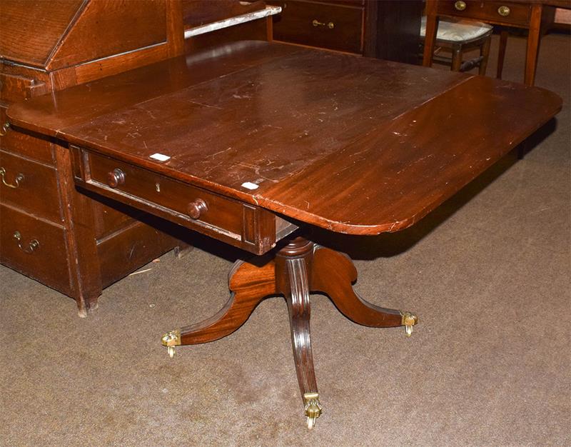 Lot 1127 - Regency mahogany centre-pedestal Pembroke table with single drawer and brass lion claw castors...