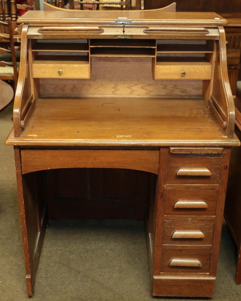 Lot 1131 - An early 20th century oak roll top desk of small proportions, 91cm by 68cm by 119cm