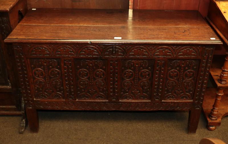 Lot 1135 - An 18th century oak four-panel coffer with stylised foliate carving, 170cm by 52cm by 70cm