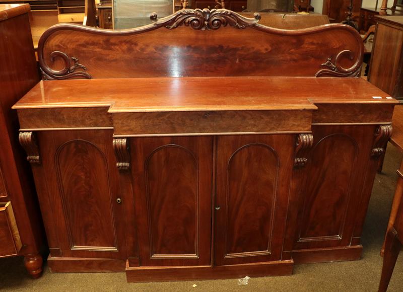 Lot 1139 - A Victorian mahogany breakfront sideboard with scrolling splashback and carved corbels, 159cm...