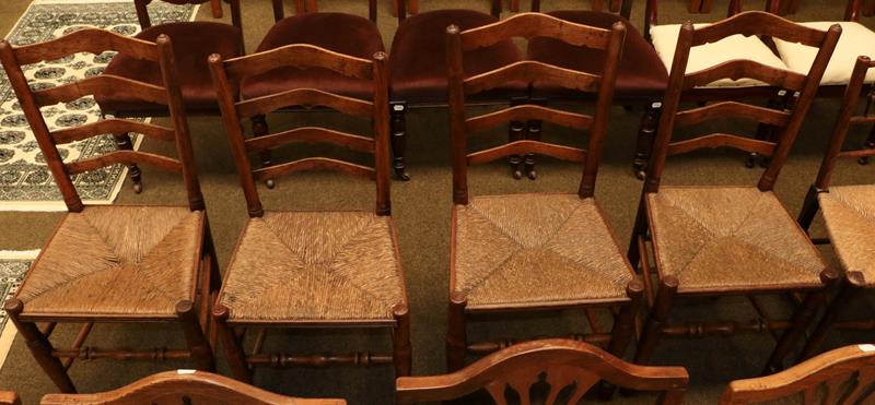Lot 1152 - A set of four early 19th century elm ladder back rush seated chairs