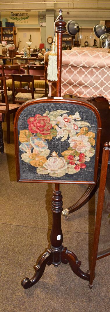 Lot 1210 - A Victorian painted glass firescreen together with a needlework pole screen of similar date and...
