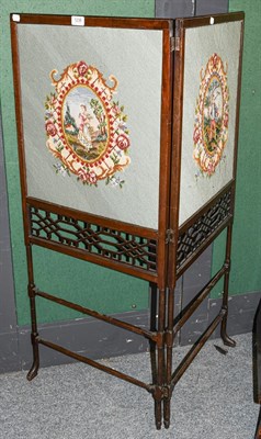 Lot 1238 - A Victorian mahogany two-fold screen with wool work panels and open fret carving, each section...