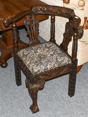 Lot 1247 - A 17th Century style carved oak corner chair with lion mask terminals, and acanthus carved cabriole