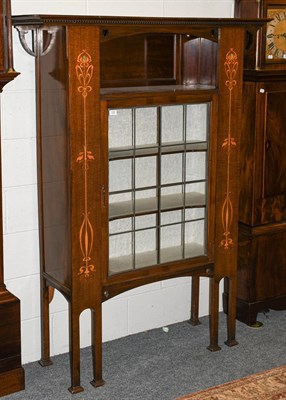 Lot 1253 - An Art Nouveau leaded glazed and marquetry inlaid mahogany display cabinet, with an overhanging...