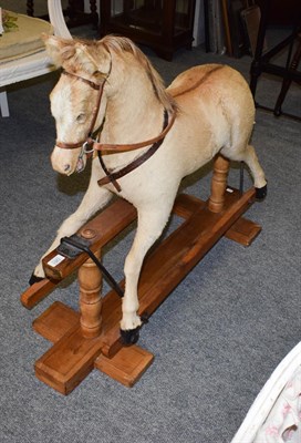 Lot 1261 - Early 20th century hide mounted rocking horse on pine trestle base, 102cm long by 98cm high to...