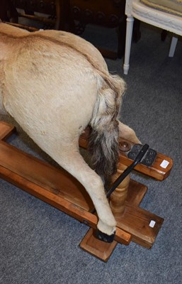 Lot 1261 - Early 20th century hide mounted rocking horse on pine trestle base, 102cm long by 98cm high to...