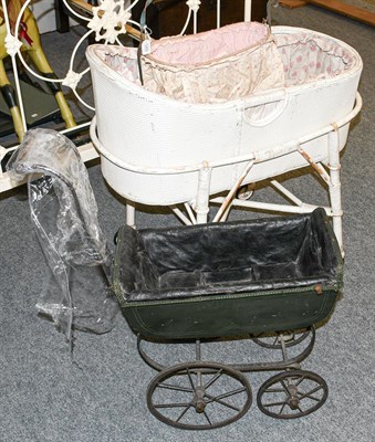 Lot 1269 - A green painted dolls pram, a wrought metal dolls cradle and bedding, a white wicker basinet on...