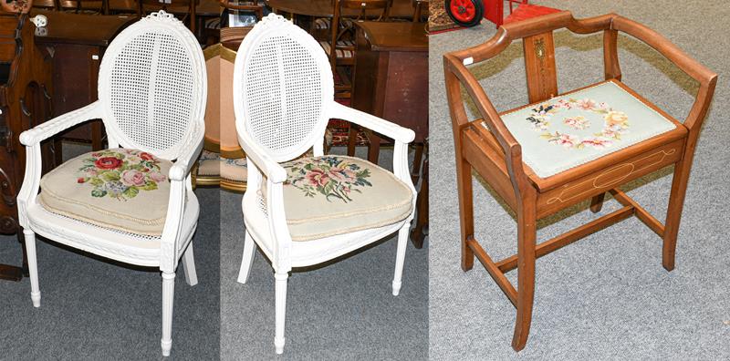 Lot 1274 - A pair of painted French fauteuil, with cane work panels, and needle work cushions together with an