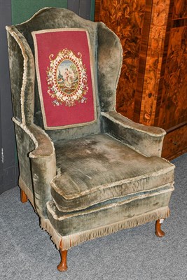 Lot 1313 - A Queen Anne style velvet upholstered wing back armchair on plain walnut cabriole supports