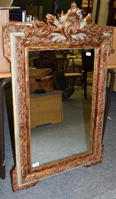 Lot 1335 - A rectangular mirror, the mildly distressed plate within a conforming leaf moulded parcel gilt...