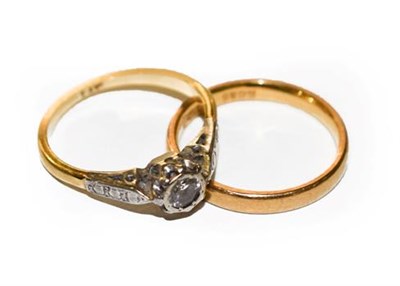 Lot 307 - A diamond solitaire ring, finger size G; and a 22 carat gold band ring, finger size G