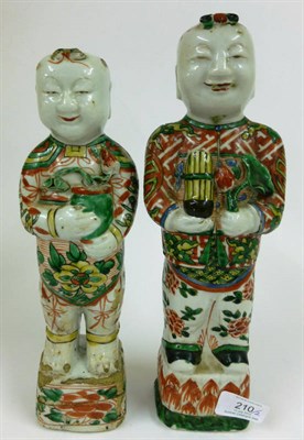Lot 210 - A Near Pair of Chinese Porcelain Figures of Boys, Kangxi, each standing, one holding a lily...