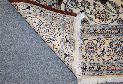 Lot 1081 - Nain Carpet, the ivory field with an all over design of scrolling vines and palmettes enclosed...