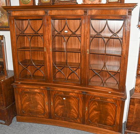 Lot 1100 - A reproduction concave mahogany bookcase, comprising three astragal glazed doors, above three...