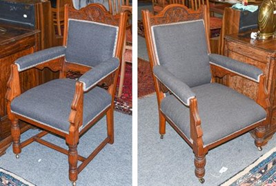 Lot 1115 - A pair of Victorian ladies and gents carved oak fireside armchairs, with grey upholstery and raised