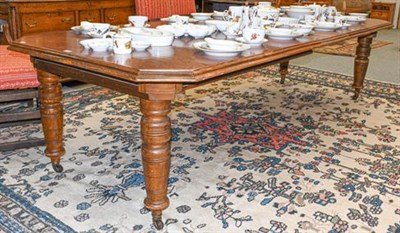 Lot 1120 - A Victorian oak wind-out dining table with three additional leaves, having canted corners and...