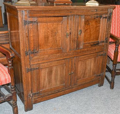 Lot 1129 - An 18th century oak court cupboard (some alterations), with moulded panel doors and iron strap...