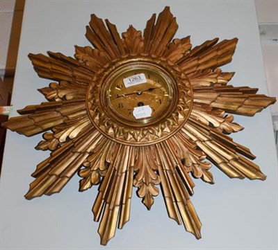 Lot 1263 - A giltwood sunburst design wall timepiece, with French movement, 52cm wide