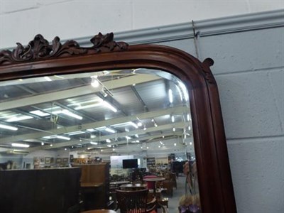 Lot 1286 - A large mahogany arched top over-mantle mirror with bevelled mirror plate, shell and scroll...