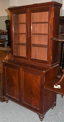 Lot 1301 - ~A Victorian mahogany bookcase raised on a two-door cupboard base, on turned feet, 101cm by 52cm by
