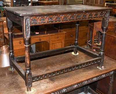 Lot 1343 - A 17th century oak plank-topped side table, with scroll carved frieze , turned supports and...