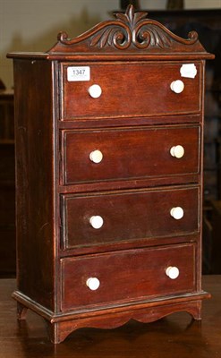 Lot 1347 - A Late Victorian mahogany miniature four-height chest of drawers, with scroll carve pediment,...