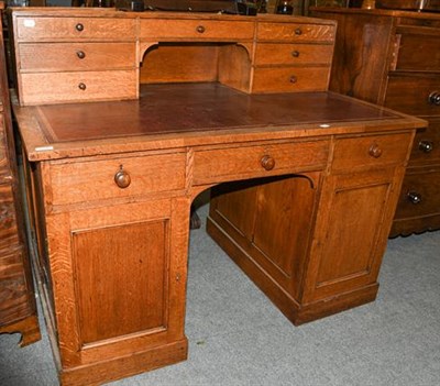 Lot 1357 - An early 20th century leather inset oak desk with superstructure, 127cm by 79cm by 105cm