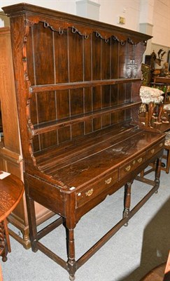 Lot 1365 - A George III Oak Open Dresser and Rack, 3rd quarter 18th century, the bold cornice above a wavy...