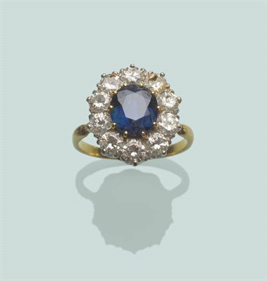 Lot 592 - A Mid 20th Century Sapphire and Diamond Cluster Ring, the oval mixed cut sapphire in a border...