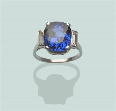 Lot 664 - A Fine Sapphire and Diamond Three Stone Ring, the cushion shaped sapphire between two baguette...