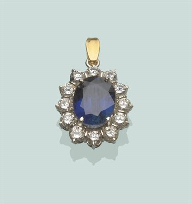 Lot 669 - An 18 Carat Gold Sapphire and Diamond Cluster Pendant, the central oval mixed cut sapphire within a