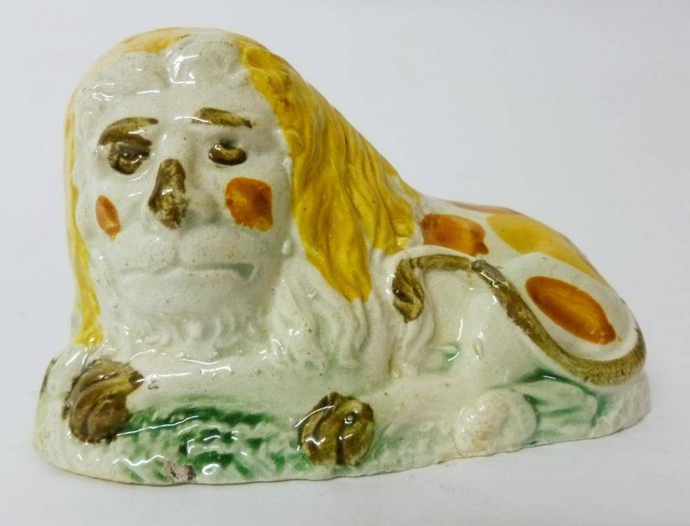 Lot 84 - A Pratt Type Pottery Figure of a Recumbent Lion, circa 1790, with yellow mane, yellow, brown...