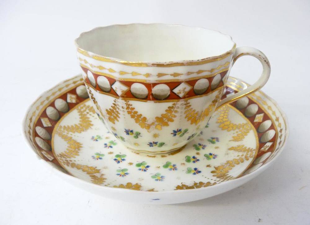 Lot 125 - A Pinxton Porcelain Teacup and Saucer, circa 1800, of fluted form, painted in colours with...