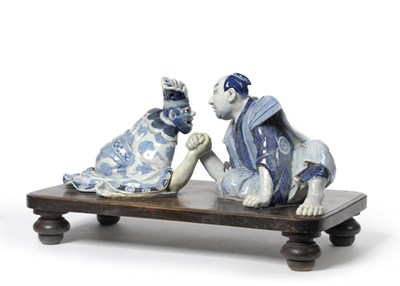 Lot 248 - An Arita Porcelain Figure Group, in 17th century style, as a man and an oni arm wrestling, both...