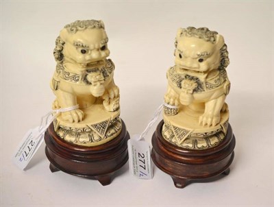 Lot 277 - A Pair of Chinese Carved and Stained Ivory Figures of Dogs of Fo, 20th century, each in typical...