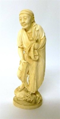 Lot 296 - A Japanese Carved Ivory Okimono as a Fisherman, early 20th century, standing in traditional...