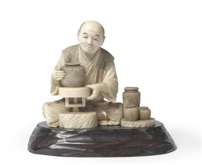 Lot 303 - A Japanese Ivory Okimono of a Potter, Meiji period, the seated figure with a vase on his...