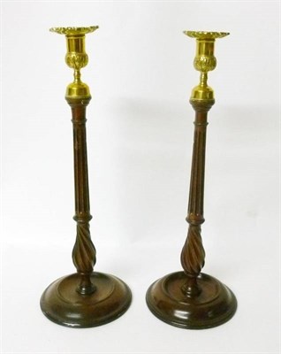 Lot 372 - A Pair of George III Mahogany Candlesticks, the foliate brass sconces on fluted stems with...