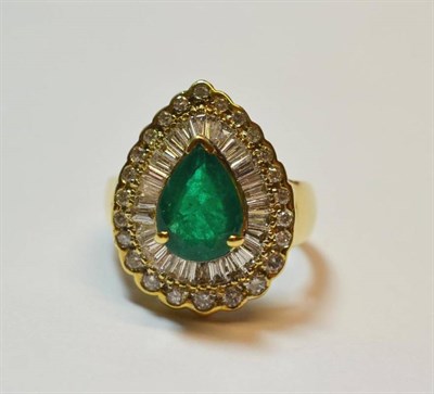 Lot 495 - An Emerald and Diamond Cluster Ring, a pear cut emerald within a border of tapered baguette cut...