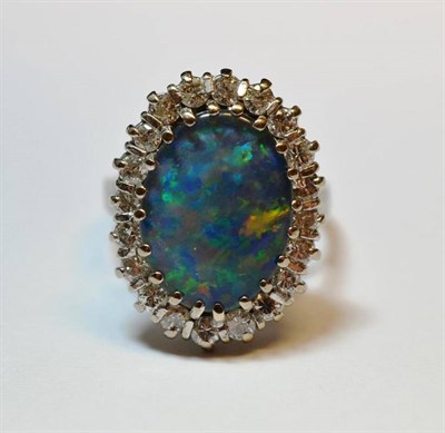 Lot 507 - An Opal Triplet and Diamond Cluster Ring, the oval triplet within a border of round brilliant...