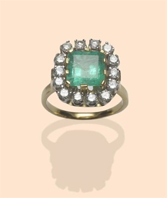 Lot 512 - An Emerald and Diamond Cluster Ring, a step cut emerald in broad yellow claw settings, within a...