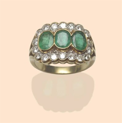 Lot 515 - An Emerald and Diamond Triple Cluster Ring, the three oval mixed cut emeralds in yellow...