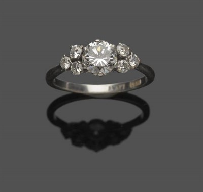 Lot 552 - A Diamond Ring, a round brilliant cut diamond flanked by a trio of smaller round brilliant cut...