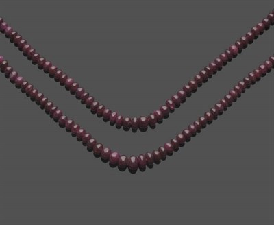 Lot 590 - A Ruby Necklace, the two strands of graduated polished ruby beads, strung to V shaped end...