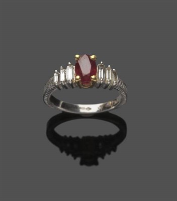 Lot 598 - A Platinum Ruby and Diamond Ring, the oval mixed cut ruby in yellow claw settings, flanked by...