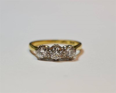 Lot 599 - A Diamond Three Stone Ring, the graduated old cut diamonds in white claw settings to a yellow...