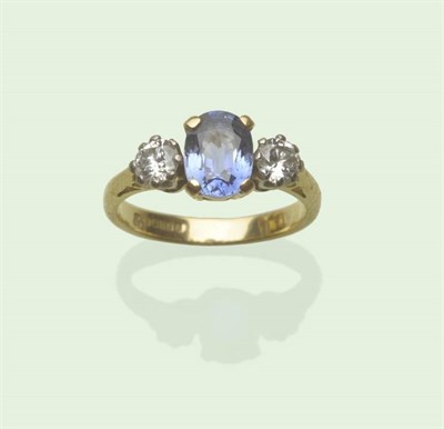 Lot 607 - An 18 Carat Gold Sapphire and Diamond Three Stone Ring, the cornflower blue oval mixed cut sapphire