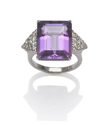 Lot 619 - An 18 Carat White Gold Amethyst and Diamond Ring, the step cut amethyst flanked by a triangular...