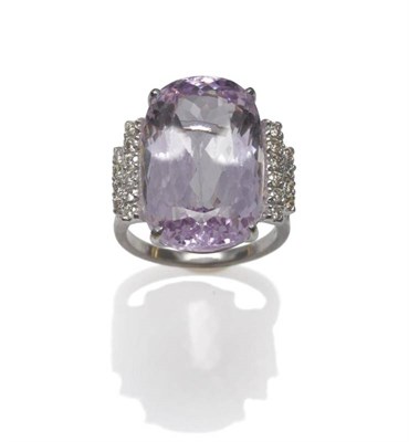 Lot 620 - An 18 Carat White Gold Kunzite and Diamond Ring, the oval cut kunzite flanked by two graduated rows